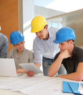 Educator with students in architecture working on electronic tablet